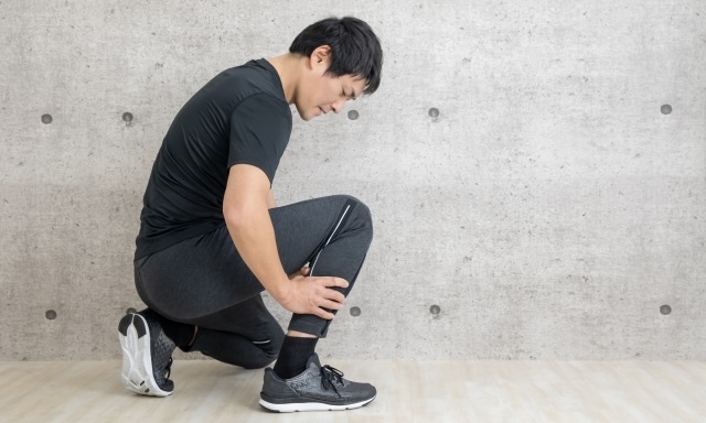 運動中にふくらはぎを押さえる男性