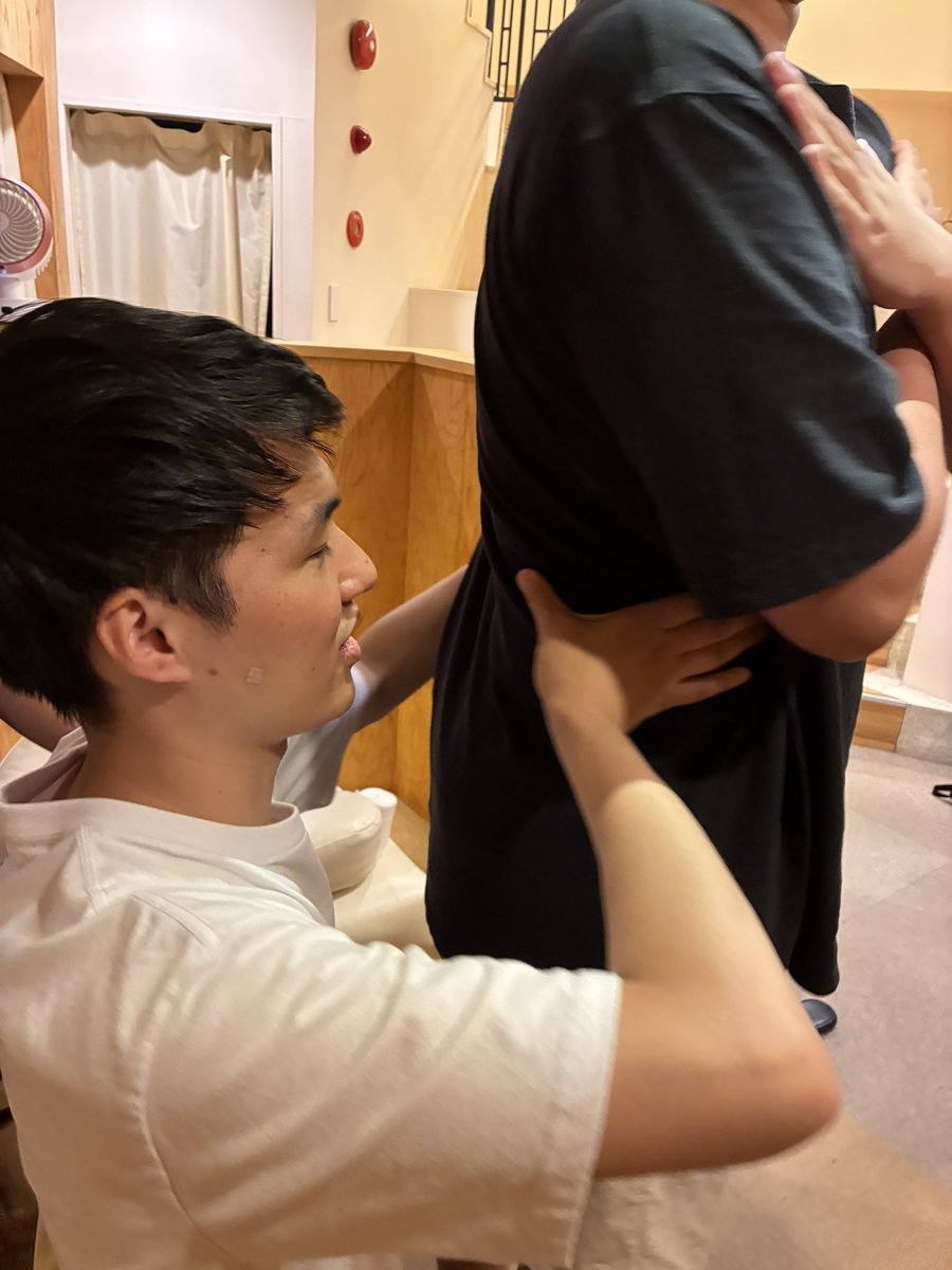 とんとん整骨院の練習会で立位の姿勢から腰の状態を確認するスタッフ