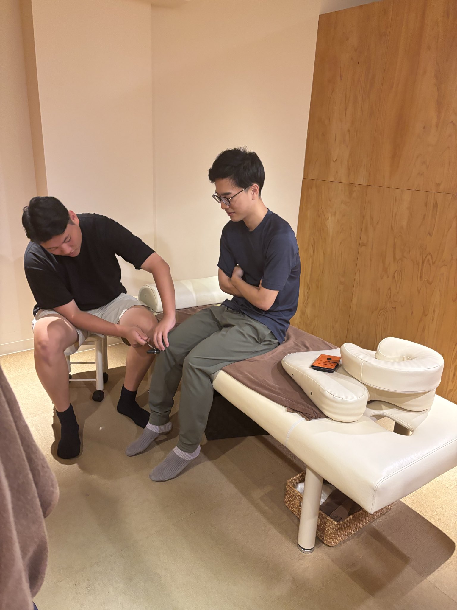 とんとん整骨院の練習会で打腱器を使った反射検査を練習するスタッフ